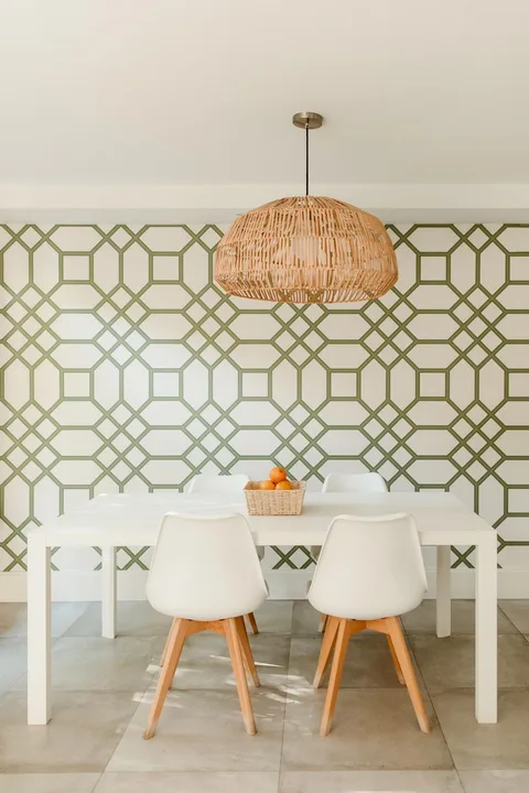 Instalación de papel pintado geométrico verde en un comedor luminoso