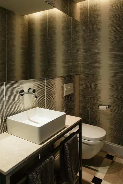 Revestimiento de líneas finas oscuras en las paredes de un baño