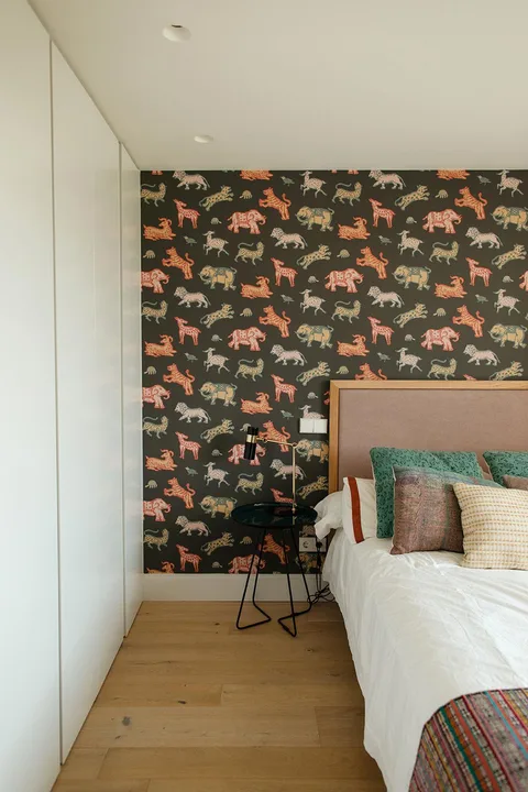 Papel pintado con animales de colores instalado en la pared de un cabecero